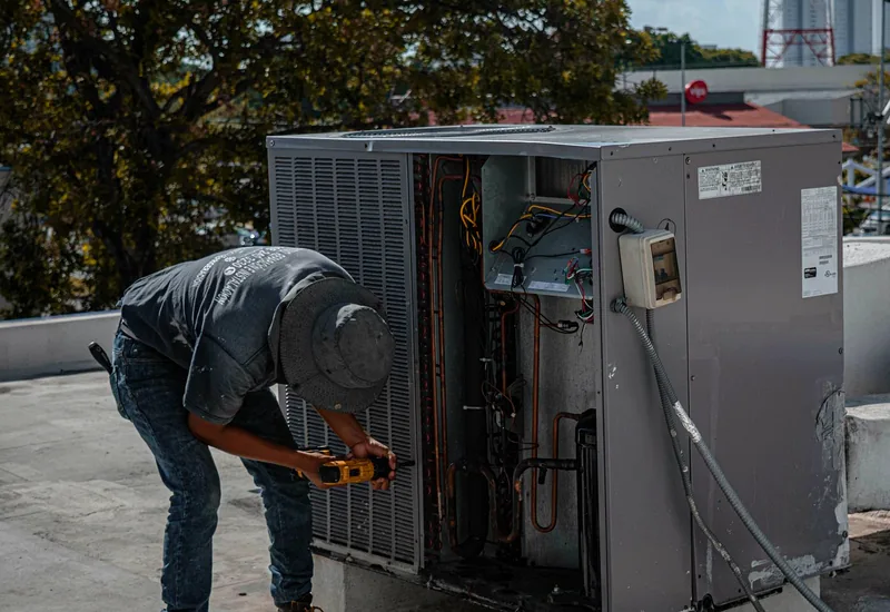 HVAC technician inspecting an outdoor condenser unit